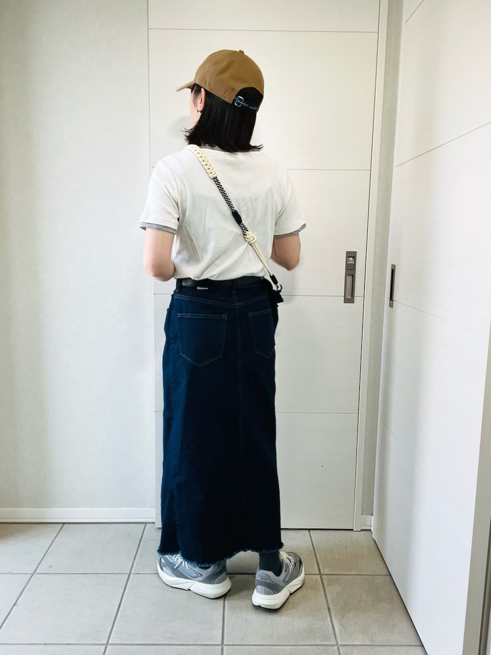 ホワイト系のTシャツ/カットソー、ブルー系のスカート、グレー系のスニーカーを着用したレディースの春コーディネートの3枚目の写真