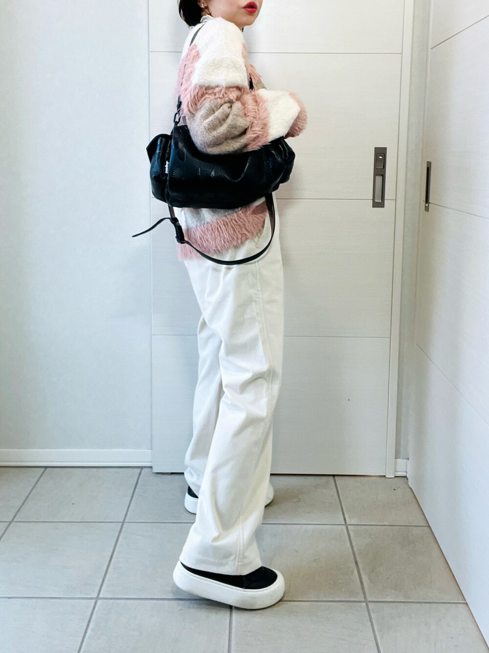 ホワイト系のニット/セーター、ホワイト系のその他パンツ、ブラック系のハンドバッグを着用したレディースの秋コーディネートの5枚目の写真