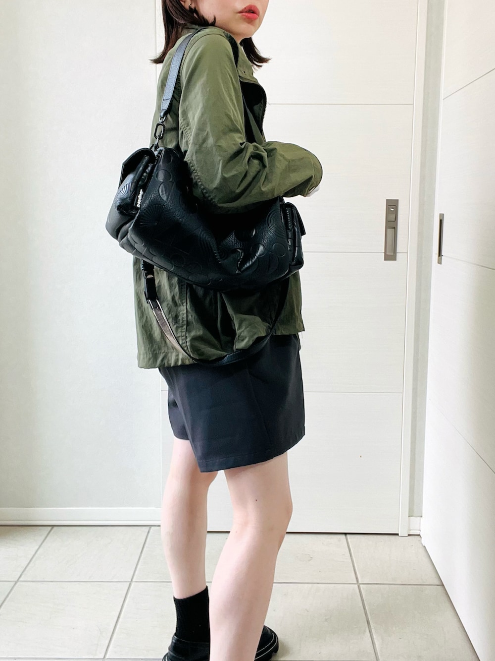 グレー系のその他パンツ、ブラック系のハンドバッグ、ホワイト系のTシャツ/カットソーを着用したレディースの秋コーディネートの3枚目の写真