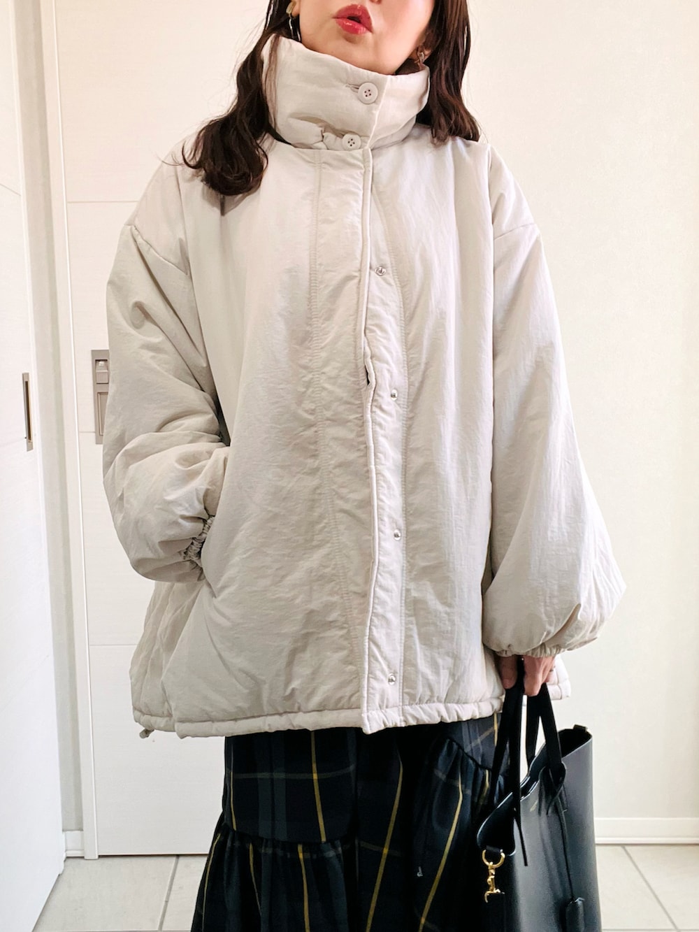 ホワイト系のブルゾン、グレー系のニット/セーター、ブラック系のスカートを着用したレディースの秋コーディネートの3枚目の写真