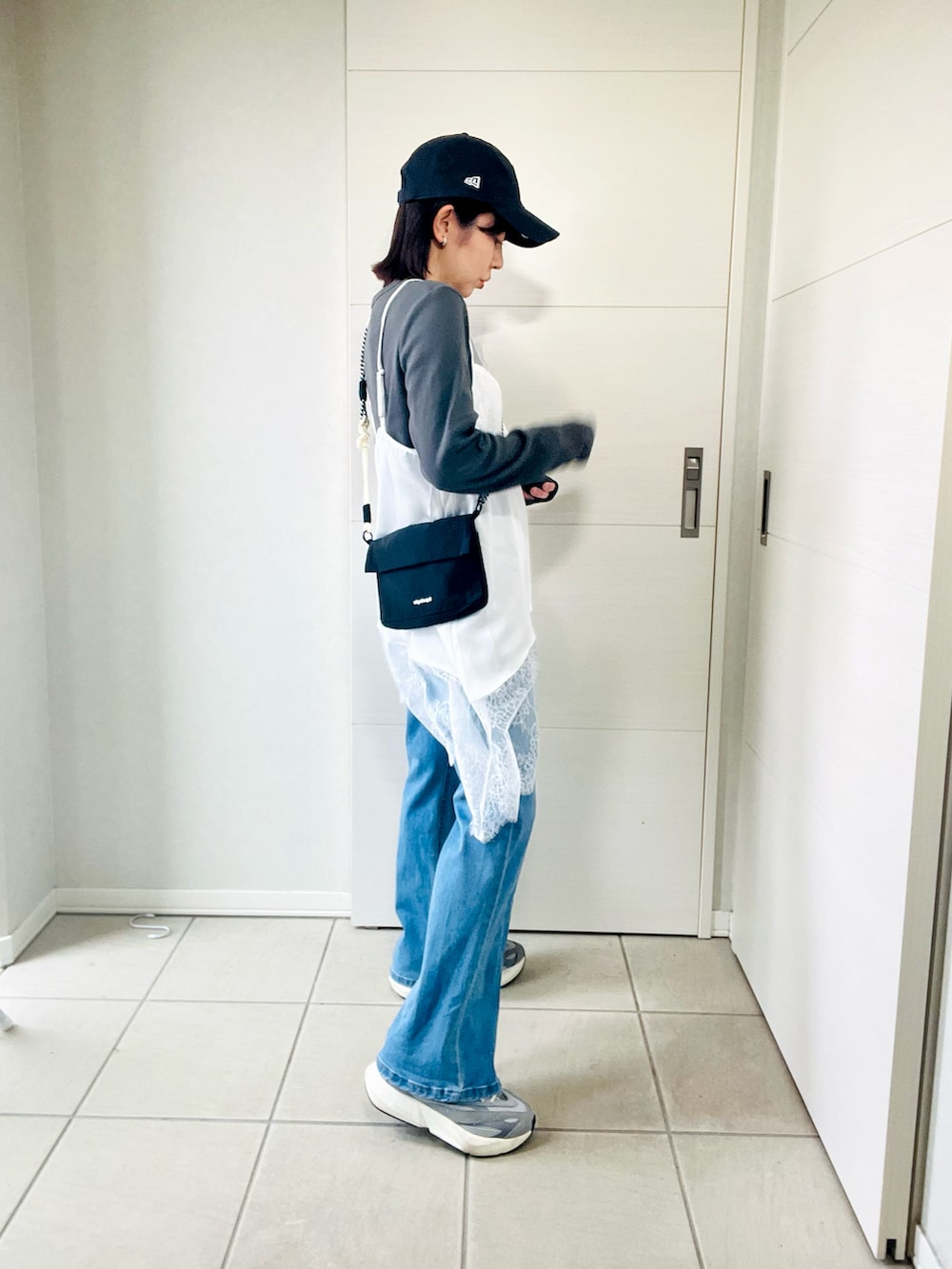 ホワイト系のキャミソール、グレー系のTシャツ/カットソー、ブルー系のデニムパンツを着用したレディースの春コーディネートの4枚目の写真