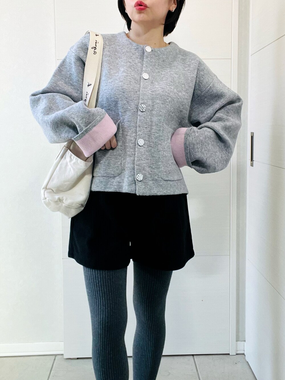 グレー系のカーディガン/ボレロ、ブラック系のバレエシューズ、ベージュ系のトートバッグを着用したレディースの秋コーディネートの2枚目の写真