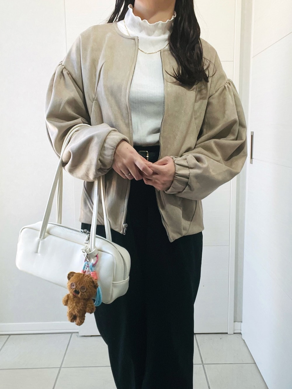ベージュ系のブルゾン、ホワイト系のTシャツ/カットソー、ブラック系のその他パンツを着用したレディースの秋コーディネートの2枚目の写真