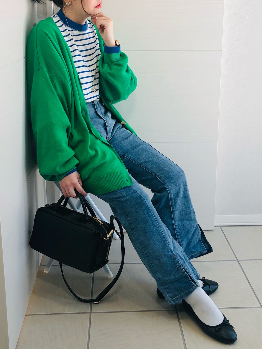 グリーン系のカーディガン/ボレロ、ブルー系のTシャツ/カットソー、ブルー系のデニムパンツを着用したレディースの冬コーディネートの3枚目の写真