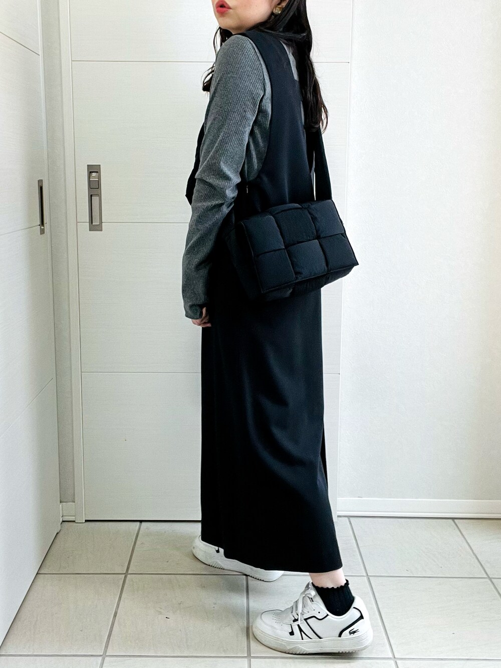 グレー系のTシャツ/カットソー、ブラック系のスカート、ホワイト系のスニーカーを着用したレディースの秋コーディネートの5枚目の写真