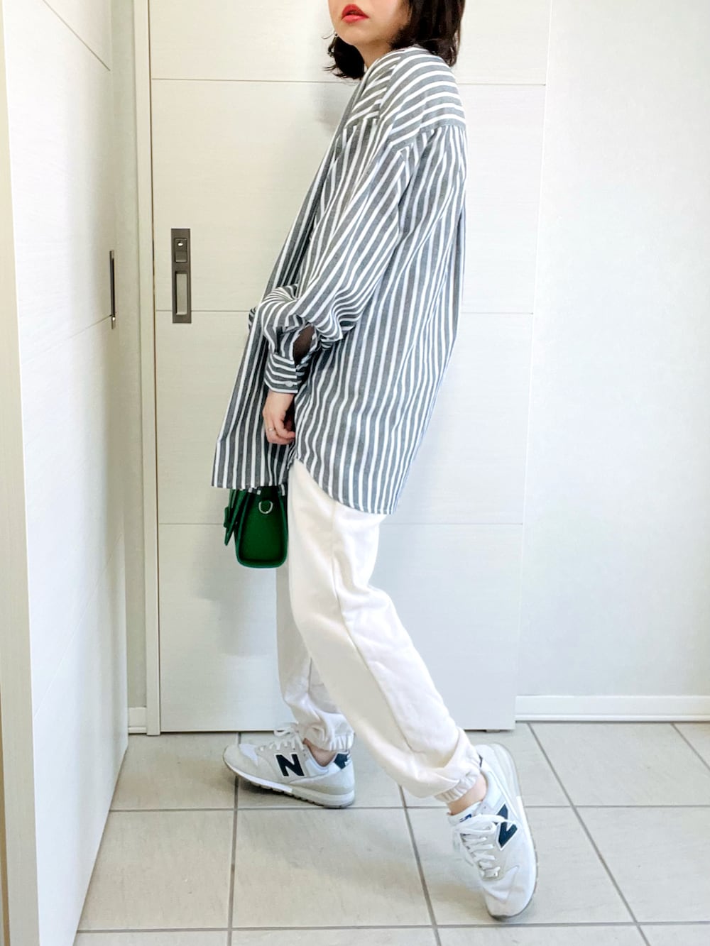 ブラック系のシャツ/ブラウス、ホワイト系のスウェットパンツ、ホワイト系のスニーカーを着用したレディースの春コーディネートの3枚目の写真