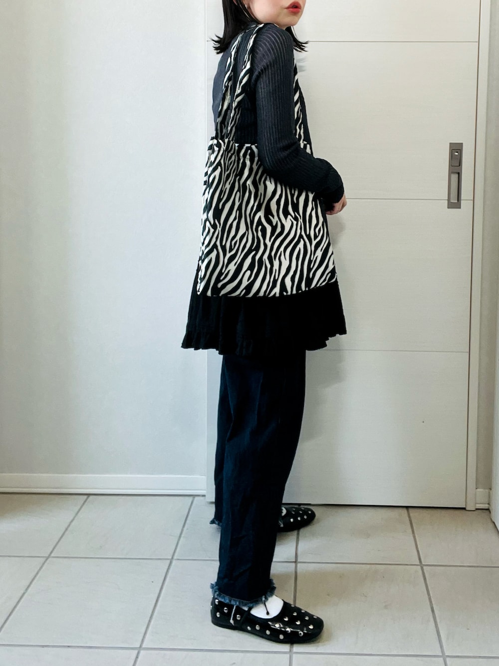 グレー系のカーディガン/ボレロ、ブラック系のワンピース、ブルー系のデニムパンツを着用したレディースの春コーディネートの5枚目の写真