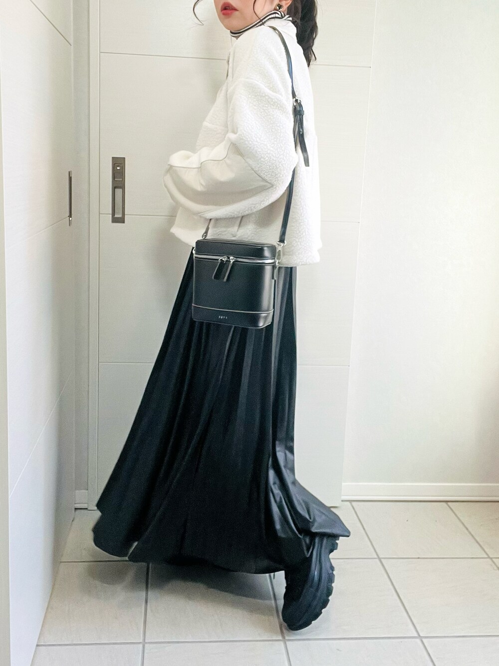 ホワイト系のTシャツ/カットソー、その他のニット/セーター、ブラック系のスカートを着用したレディースの冬コーディネートの5枚目の写真