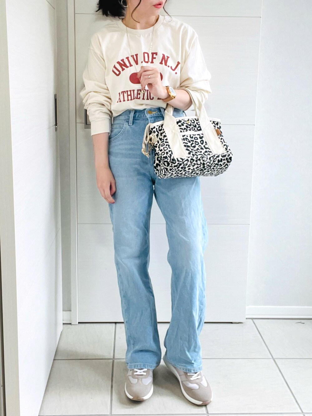 ベージュ系のTシャツ/カットソー、ブルー系のデニムパンツ、ベージュ系のスニーカーを着用したレディースの夏コーディネートの3枚目の写真