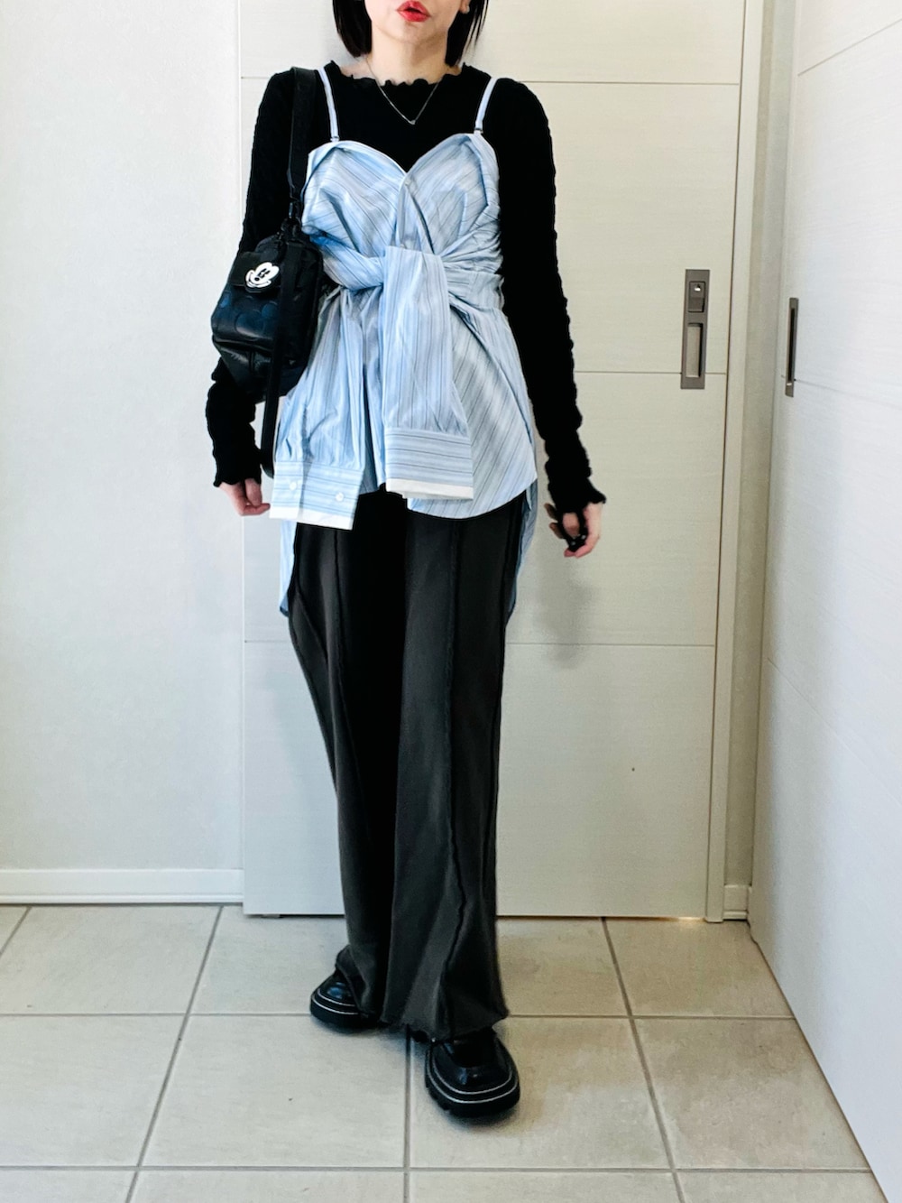 ブルー系のシャツ/ブラウス、ブラック系のスウェットパンツ、ブラック系のハンドバッグを着用したレディースの冬コーディネートの4枚目の写真