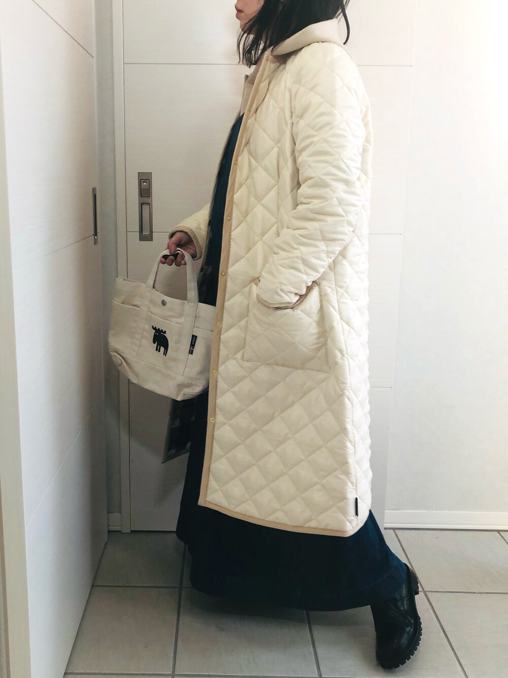 ホワイト系のノーカラーコート、ブルー系のセットアップ、ブラック系のブーツを着用したレディースの秋コーディネートの4枚目の写真