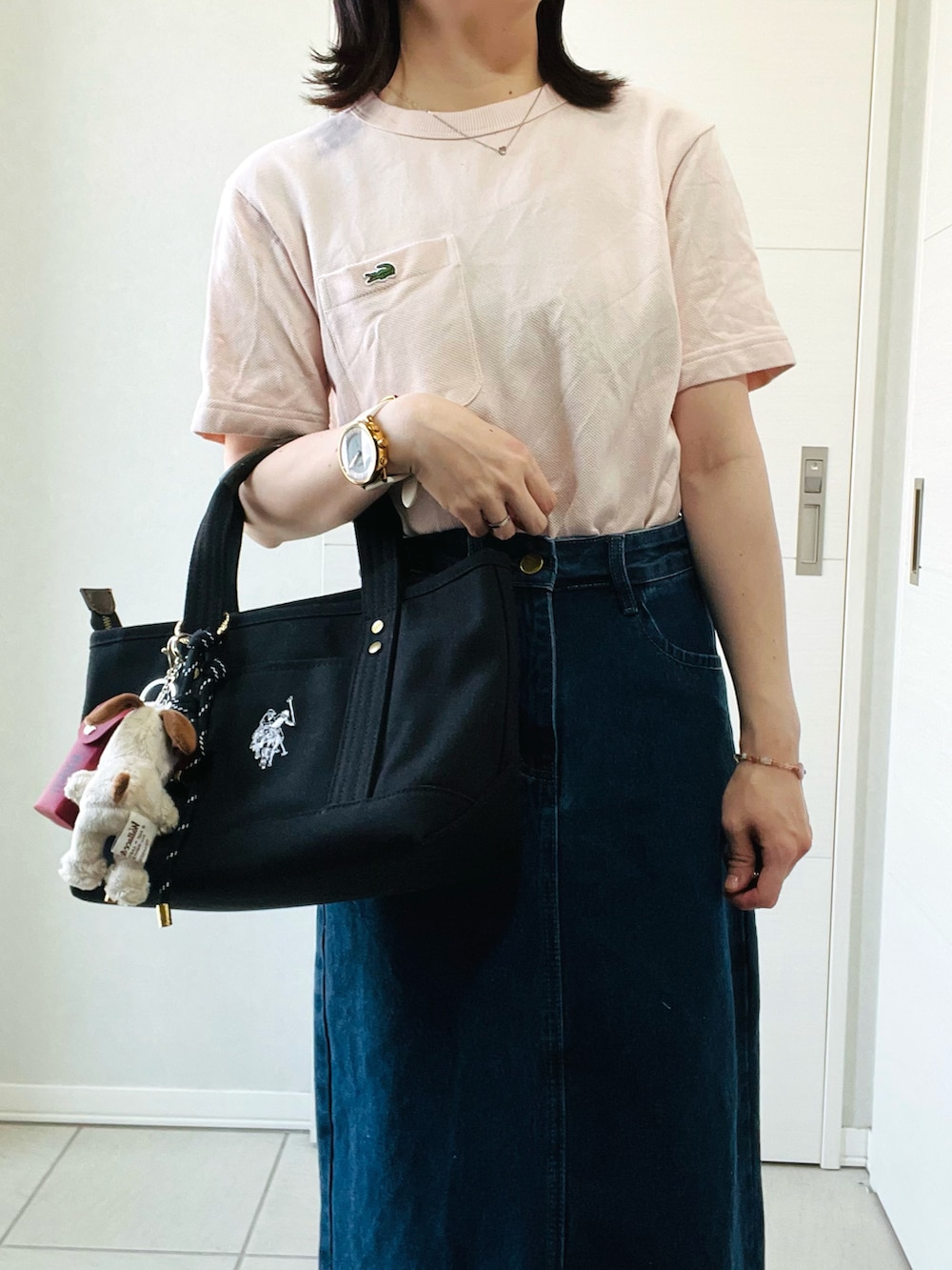 ピンク系のTシャツ/カットソー、ブルー系のデニムスカート、ホワイト系のスニーカーを着用したレディースの夏コーディネートの2枚目の写真