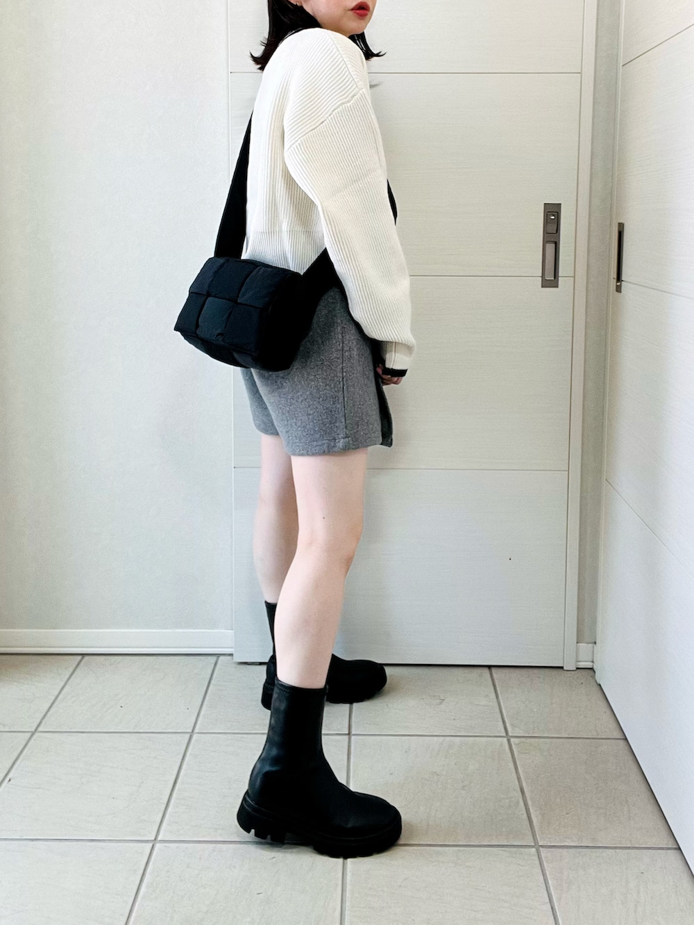 ホワイト系のニット/セーター、ブラック系のブーツ、グレー系のその他パンツを着用したレディースの秋コーディネートの5枚目の写真