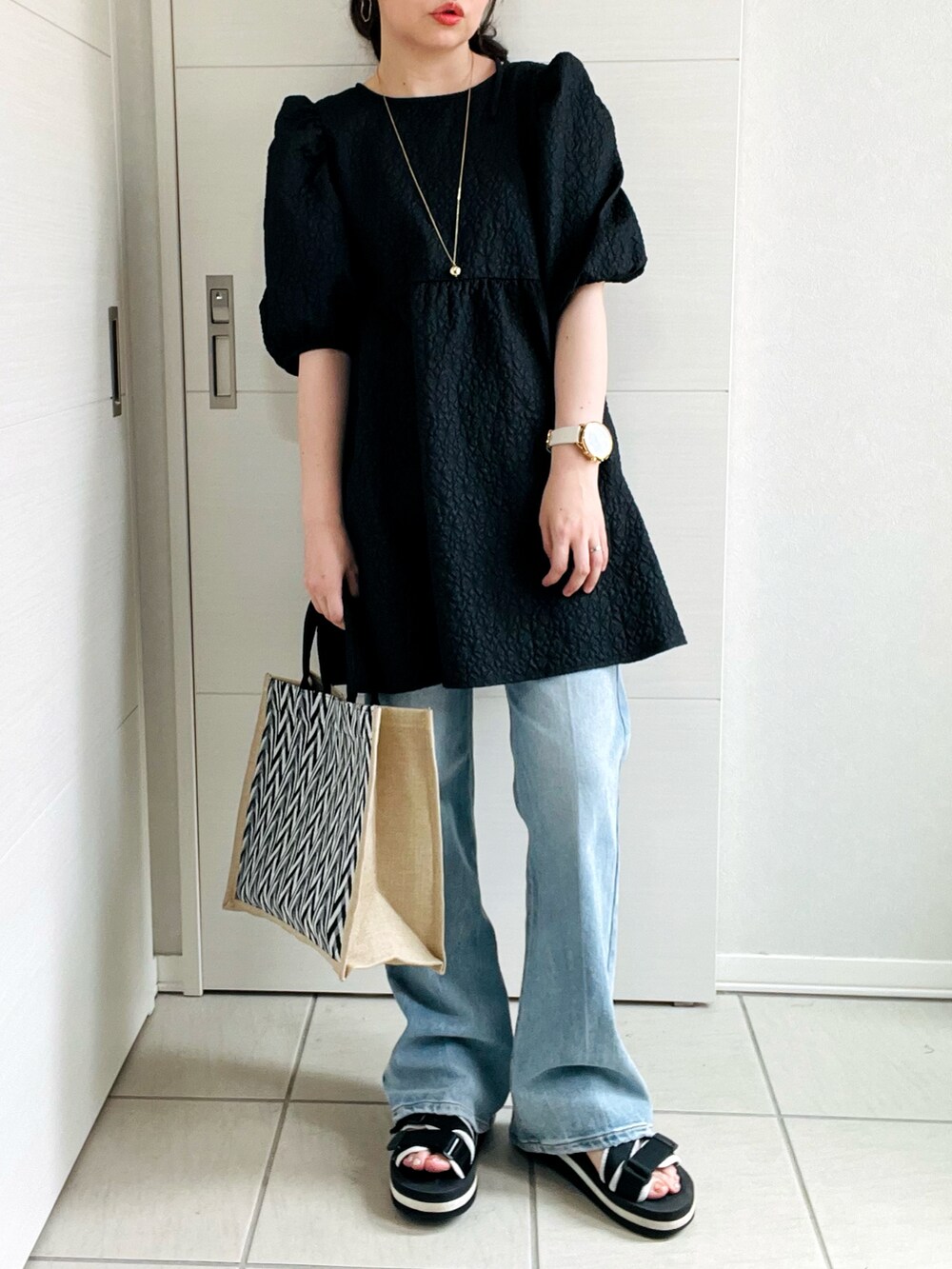 ブラック系のシャツ/ブラウス、ブルー系のデニムパンツ、ブラック系のサンダルを着用したレディースの夏コーディネートの2枚目の写真