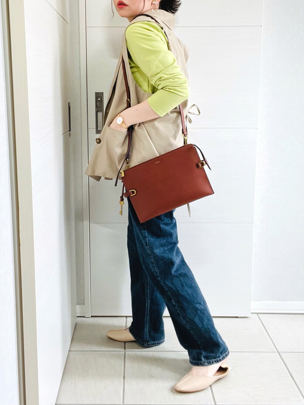 ブラウン系のメッセンジャーバッグ、グリーン系のTシャツ/カットソー、ベージュ系のテーラードジャケットを着用したレディースの春コーディネートの5枚目の写真