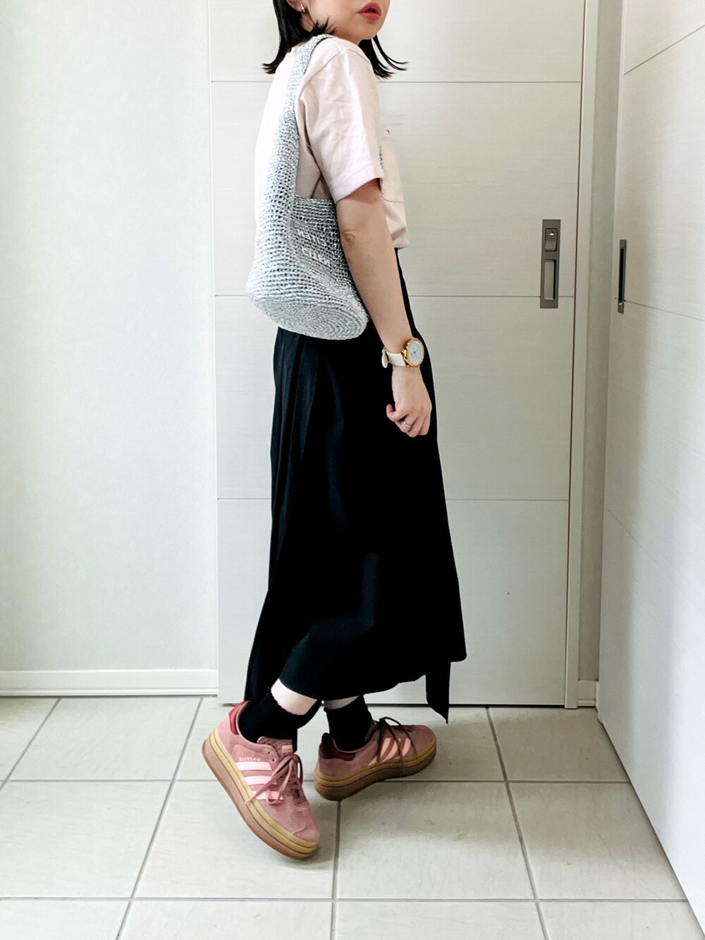 ピンク系のTシャツ/カットソー、ブラック系のスカート、レッド系のスニーカーを着用したレディースの春コーディネートの5枚目の写真