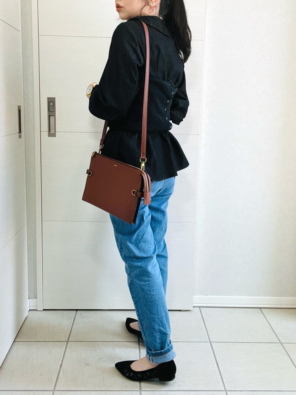 ブラック系のシャツ/ブラウス、ブラック系のベスト、ブルー系のデニムパンツを着用したレディースの春コーディネートの3枚目の写真