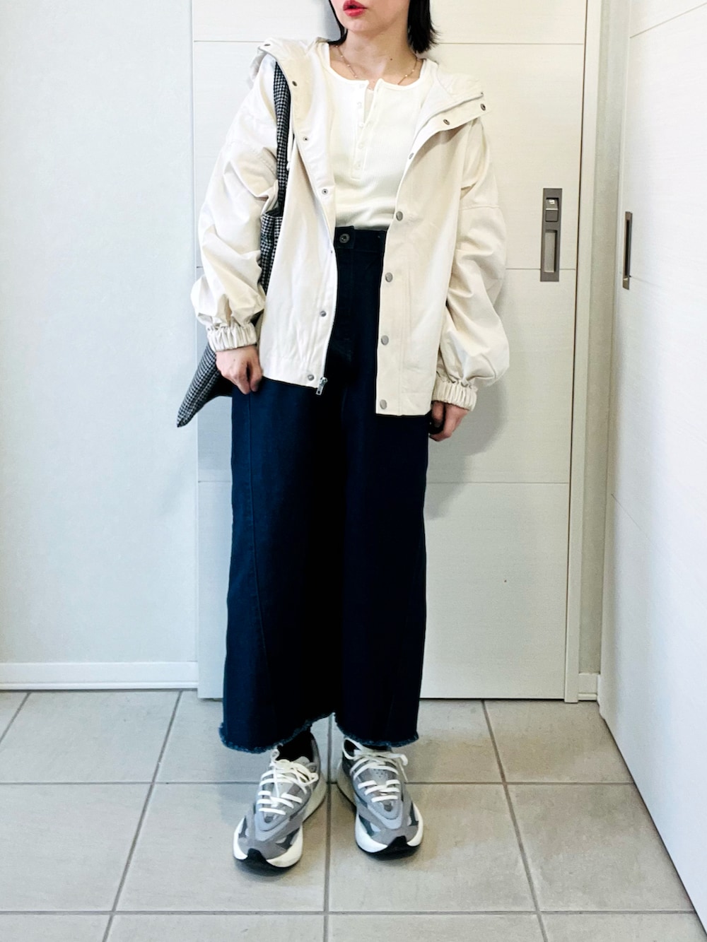 ホワイト系のマウンテンパーカー、グレー系のスニーカー、ホワイト系のTシャツ/カットソーを着用したレディースの春コーディネートの5枚目の写真