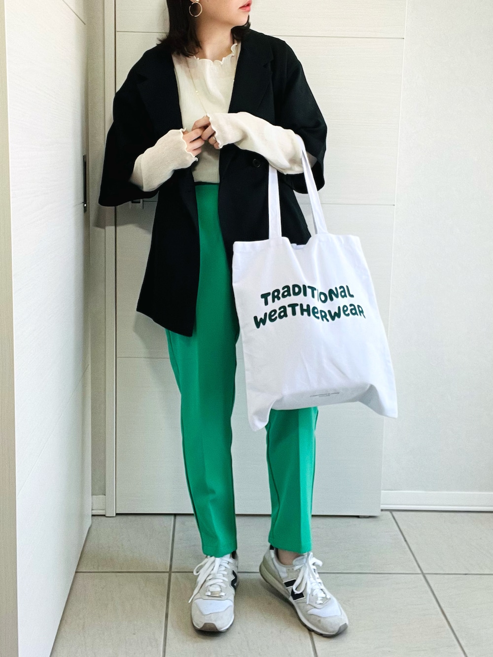 ブラック系のシャツ/ブラウス、グリーン系のスラックス、ホワイト系のスニーカーを着用したレディースの春コーディネートの2枚目の写真