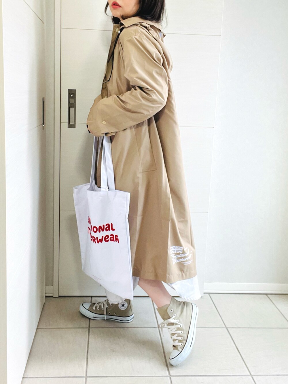 ベージュ系のシャツワンピース、ベージュ系のスニーカー、ホワイト系のトートバッグを着用したレディースの春コーディネートの3枚目の写真
