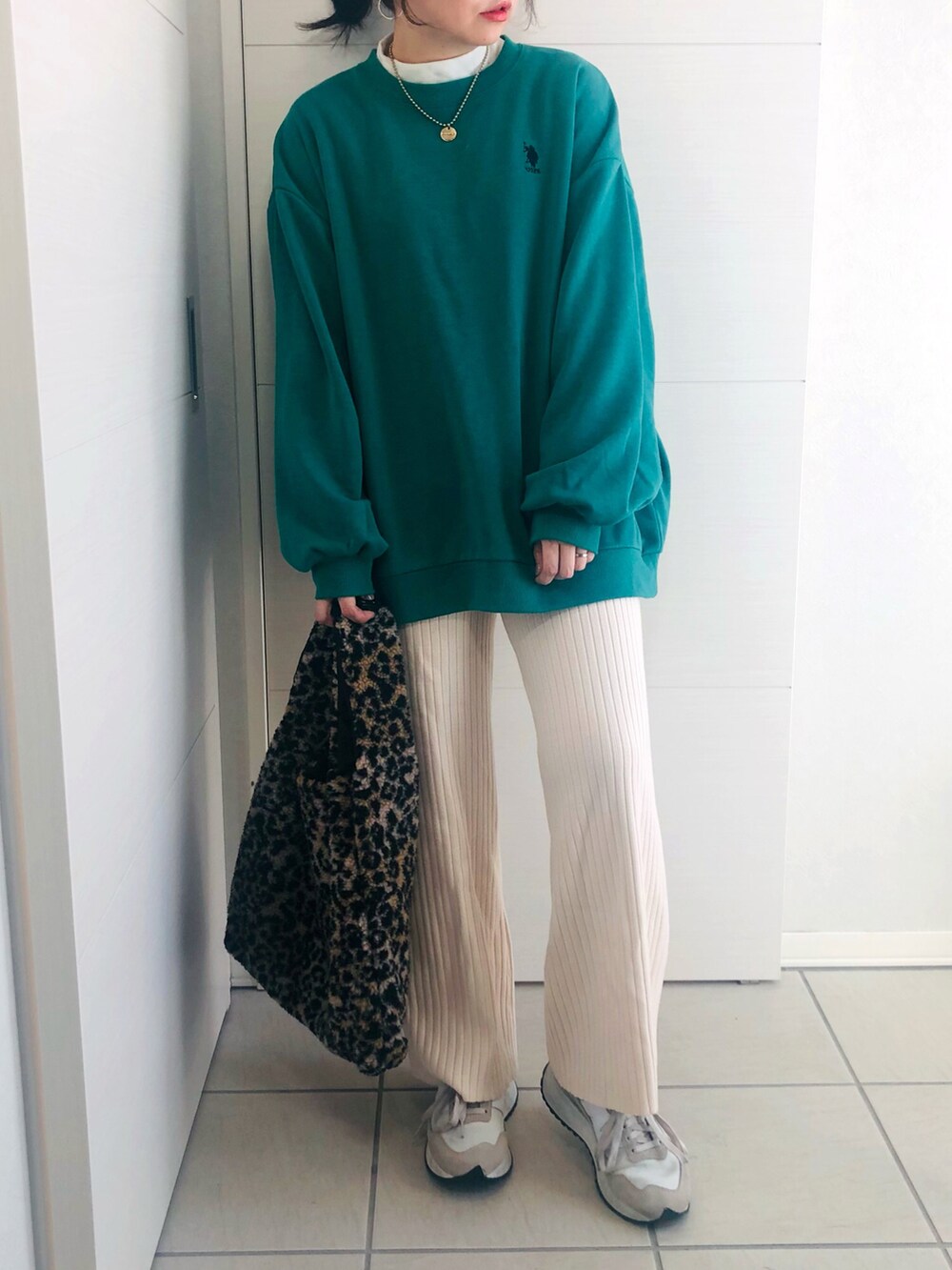 グリーン系のスウェット、ホワイト系のその他パンツ、ホワイト系のスニーカーを着用したレディースの冬コーディネートの4枚目の写真