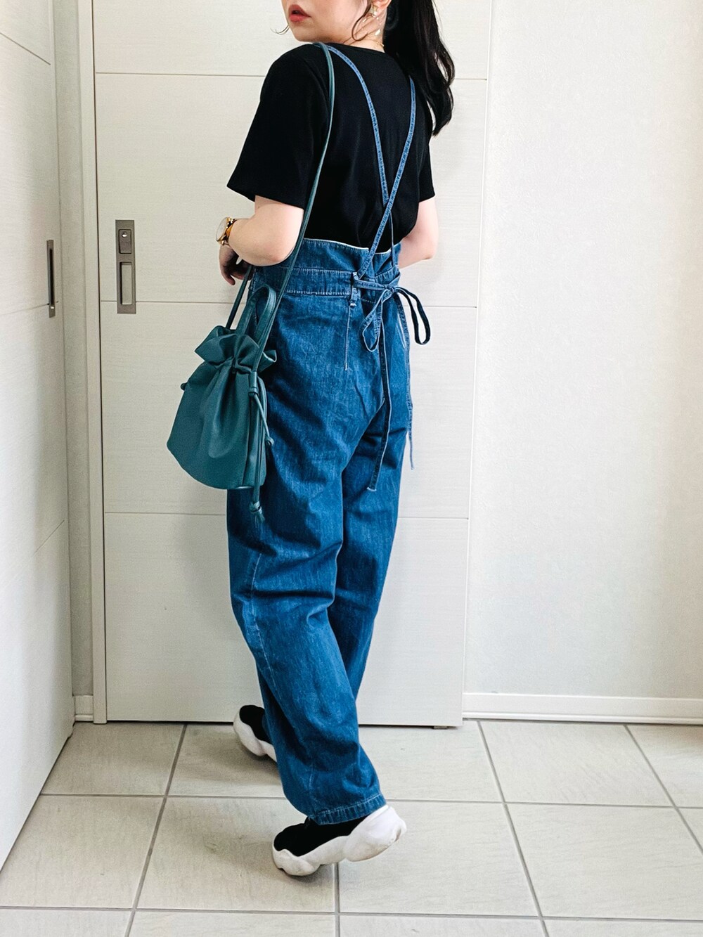 ブルー系のサロペット/オーバーオール、ブラック系のTシャツ/カットソー、ブラック系のスニーカーを着用したレディースの夏コーディネートの4枚目の写真