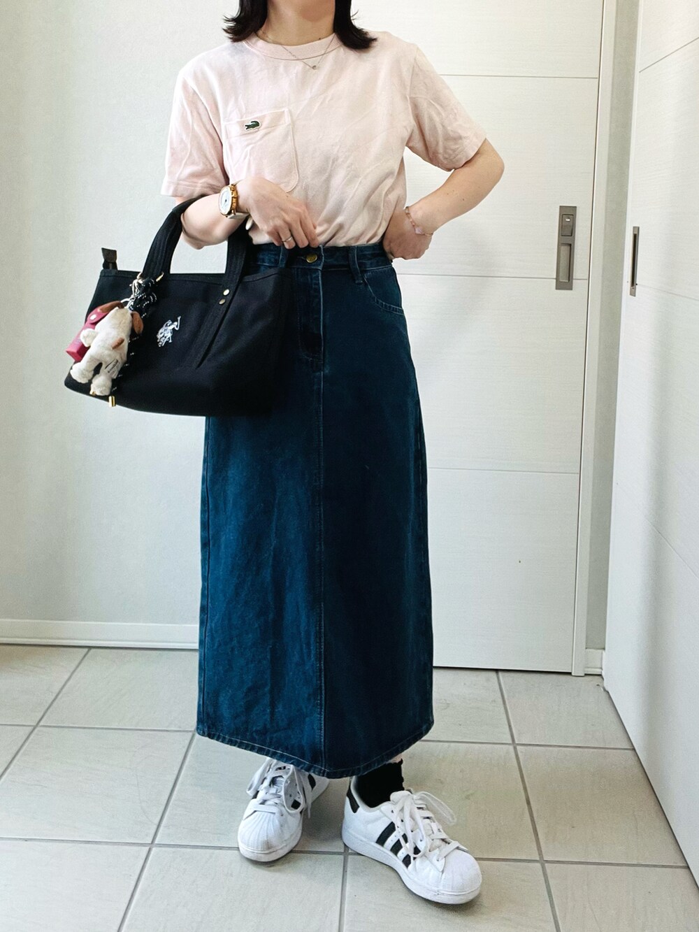 ピンク系のTシャツ/カットソー、ブルー系のデニムスカート、ホワイト系のスニーカーを着用したレディースの夏コーディネートの4枚目の写真