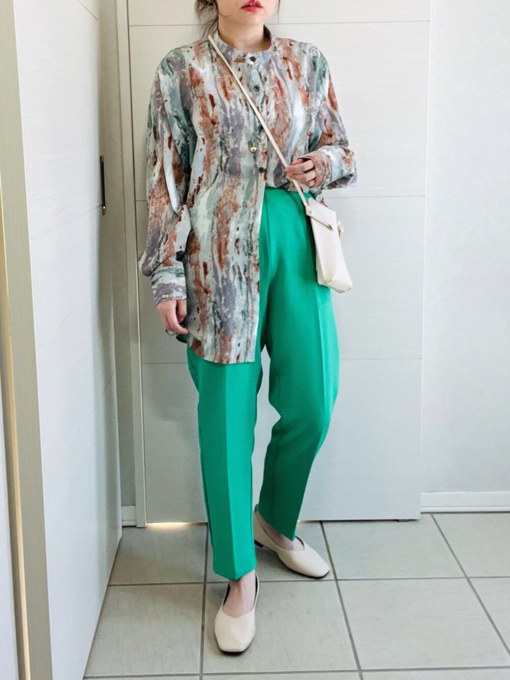 グリーン系のスラックス、グリーン系のシャツ/ブラウス、ホワイト系のバレエシューズを着用したレディースの冬コーディネートの3枚目の写真