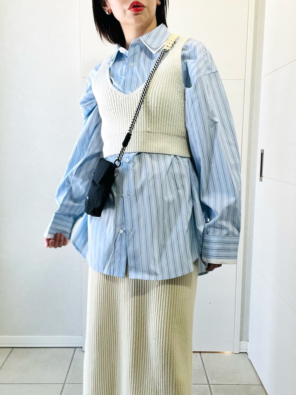 ブルー系のシャツ/ブラウス、ホワイト系のスカート、ブラック系のショルダーバッグを着用したレディースの冬コーディネートの3枚目の写真