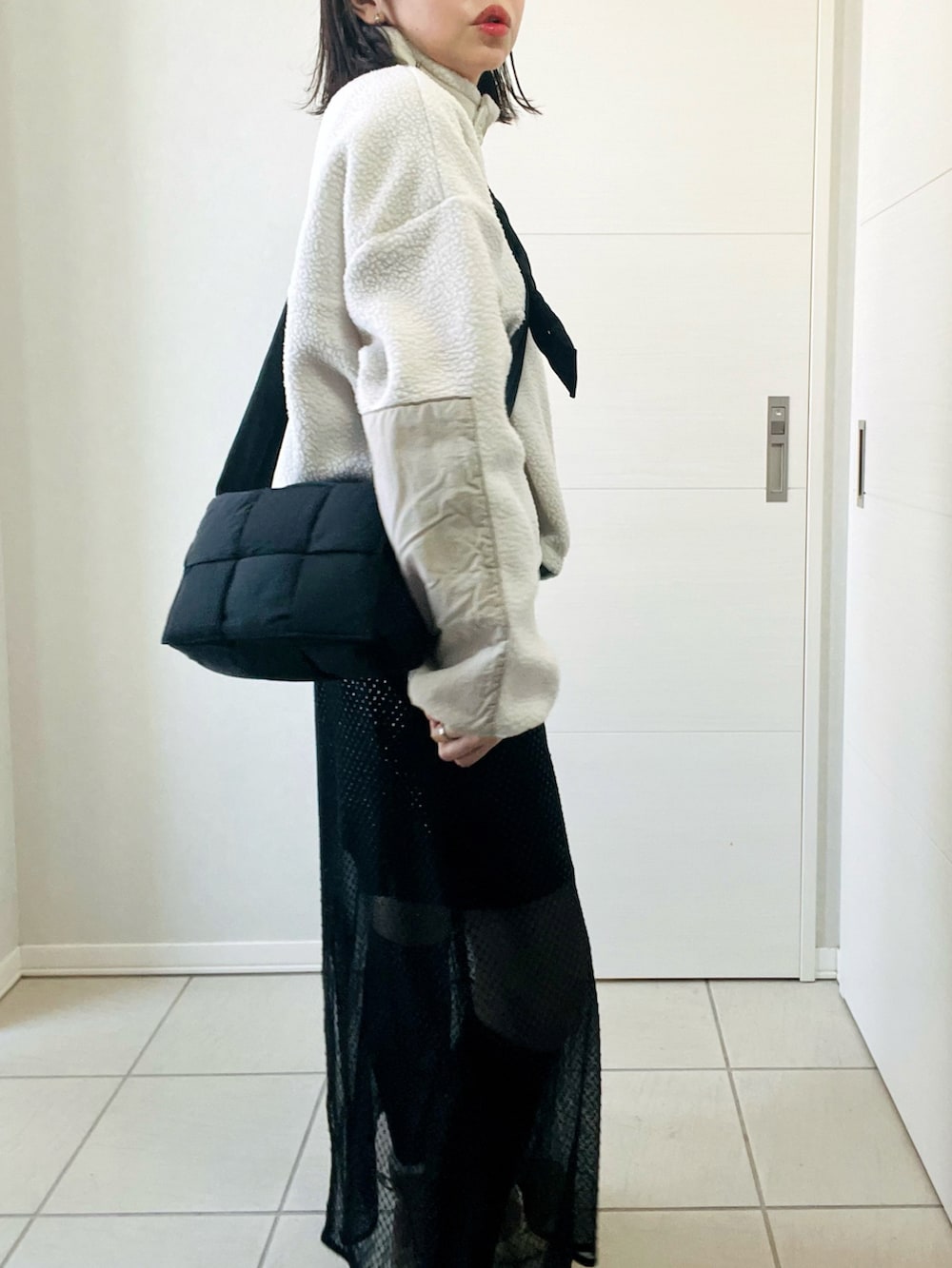 ホワイト系のTシャツ/カットソー、ブラック系のスカート、ブラウン系のブーツを着用したレディースの冬コーディネートの3枚目の写真