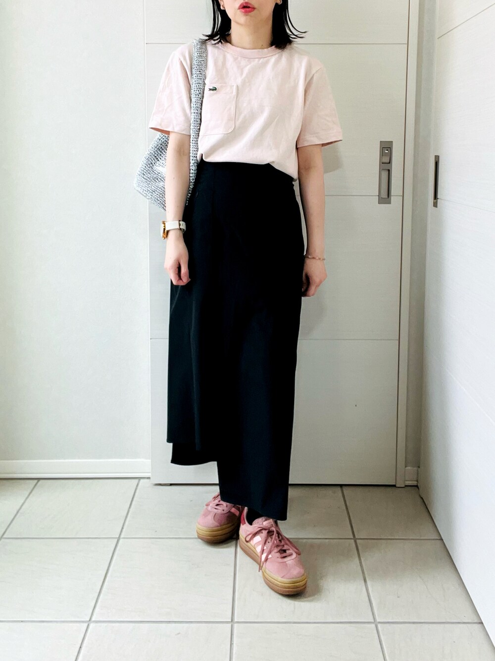 ピンク系のTシャツ/カットソー、ブラック系のスカート、レッド系のスニーカーを着用したレディースの春コーディネートの4枚目の写真