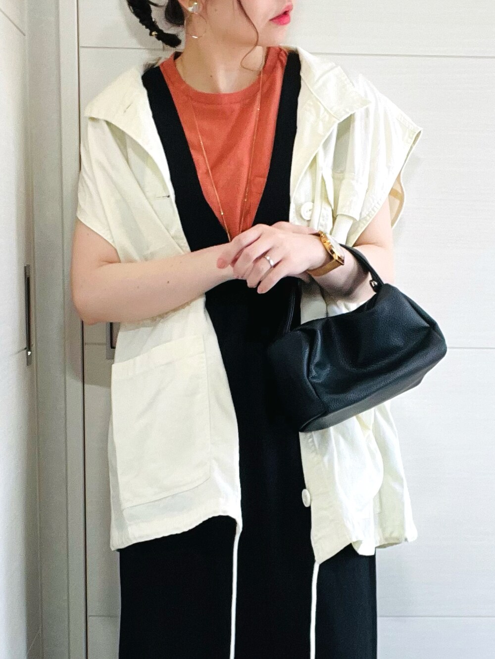 ホワイト系のベスト、オレンジ系のTシャツ/カットソー、ブラック系のワンピースを着用したレディースの夏コーディネートの4枚目の写真