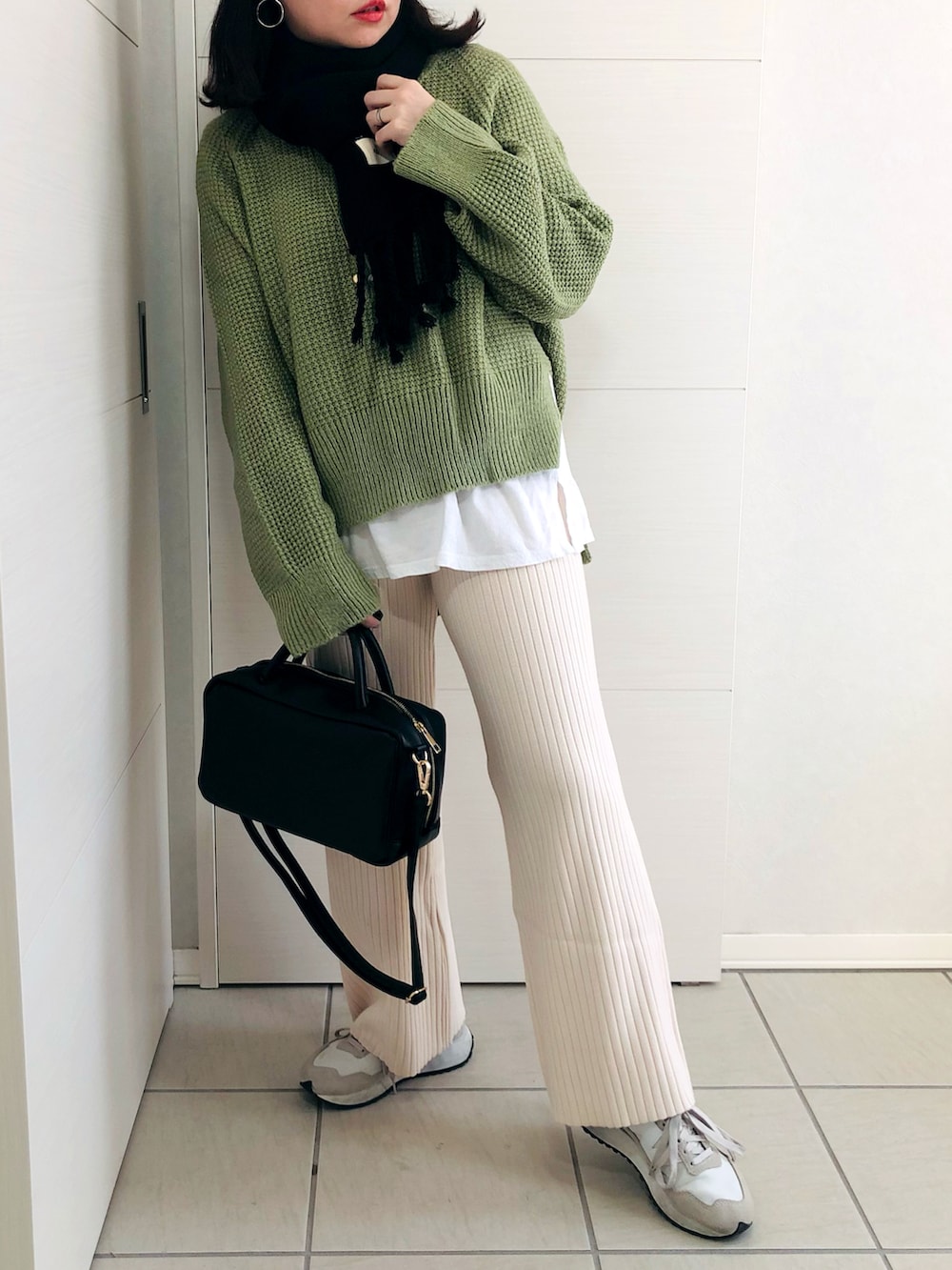 グリーン系のニット/セーター、ホワイト系のその他パンツ、ホワイト系のスニーカーを着用したレディースの冬コーディネートの2枚目の写真