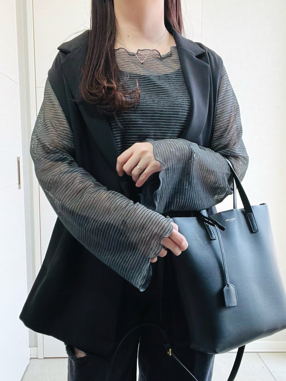 グレー系のTシャツ/カットソー、ブラック系のベスト、ブラック系のデニムパンツを着用したレディースの春コーディネートの3枚目の写真