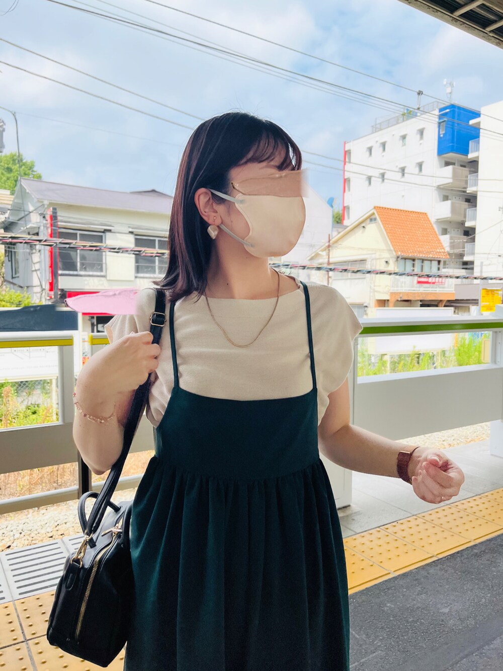 ベージュ系のニット/セーター、グリーン系のサロペット/オーバーオール、ベージュ系のサンダルを着用したレディースの夏コーディネートの4枚目の写真