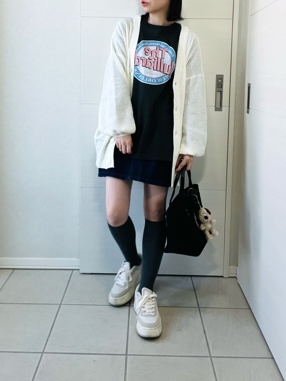 ホワイト系のカーディガン/ボレロ、グレー系のTシャツ/カットソー、ブルー系のデニムスカートを着用したレディースの春コーディネートの4枚目の写真