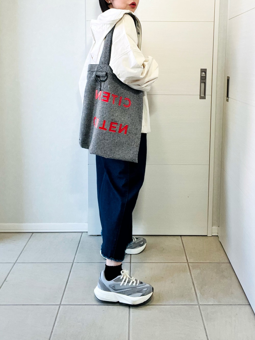 ホワイト系のマウンテンパーカー、グレー系のスニーカー、ホワイト系のTシャツ/カットソーを着用したレディースの春コーディネートの4枚目の写真