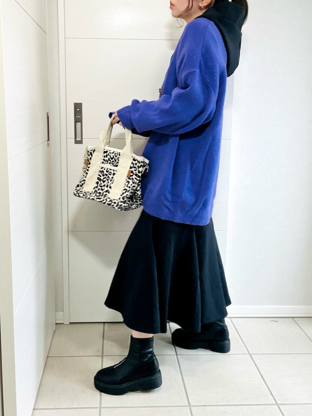 ブラック系のワンピース、パープル系のカーディガン/ボレロ、ブラック系のブーツを着用したレディースの秋コーディネートの4枚目の写真