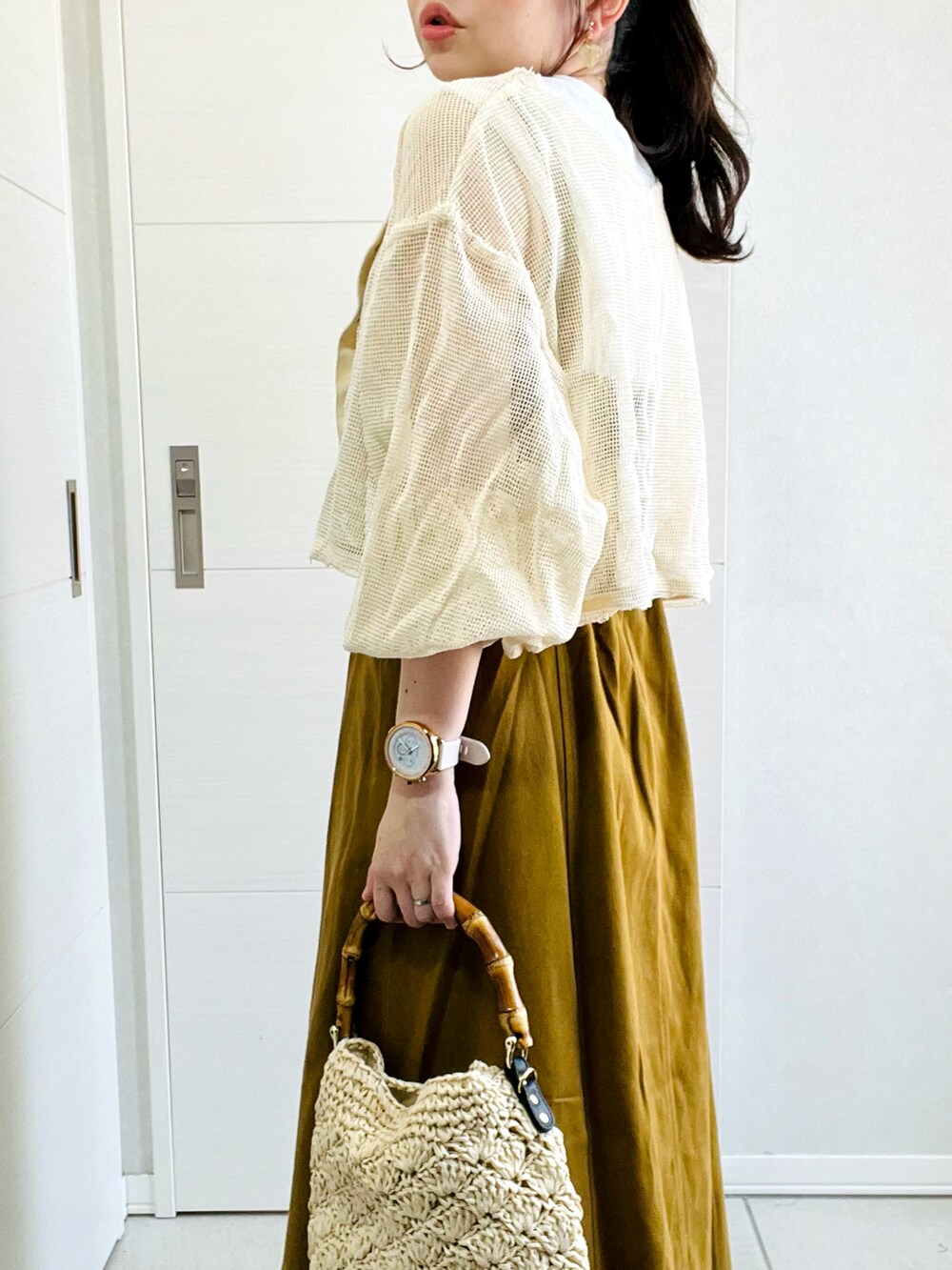 ホワイト系のカーディガン/ボレロ、イエロー系のワンピース、ブラック系のサンダルを着用したレディースの夏コーディネートの4枚目の写真