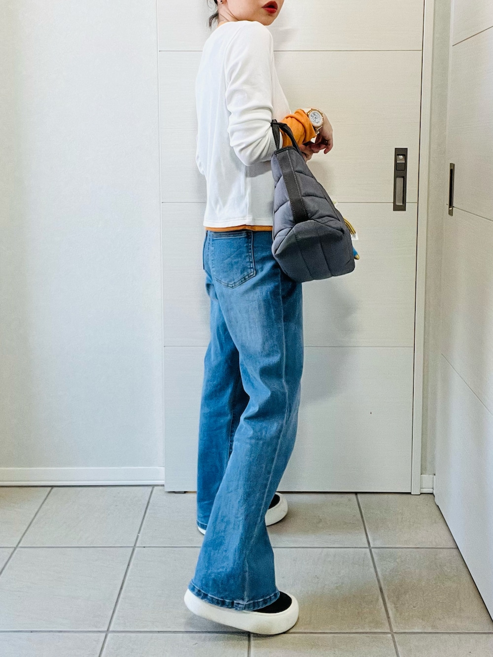 ブルー系のデニムパンツ、ホワイト系のTシャツ/カットソー、ブラック系のスニーカーを着用したレディースの春コーディネートの5枚目の写真