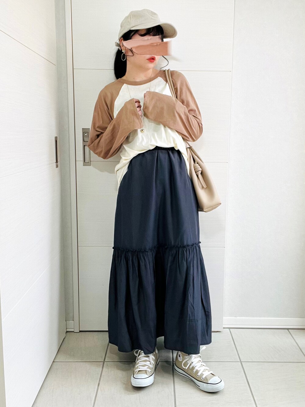 ホワイト系のマウンテンパーカー、ブラウン系のTシャツ/カットソー、グレー系のスカートを着用したレディースの春コーディネートの4枚目の写真