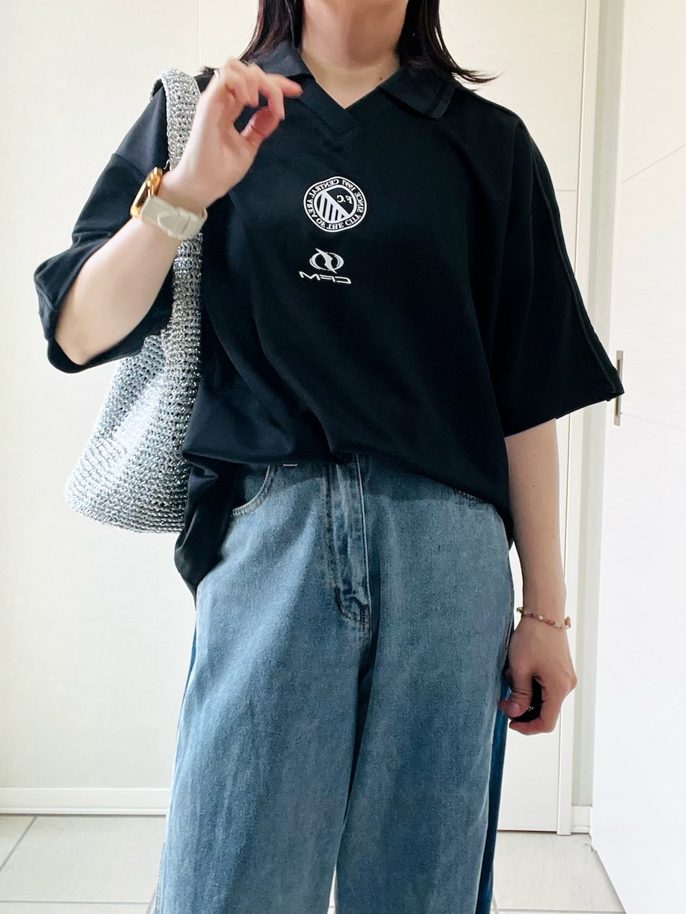 ブラック系のTシャツ/カットソー、ブルー系のデニムパンツ、レッド系のスニーカーを着用したレディースの夏コーディネートの3枚目の写真