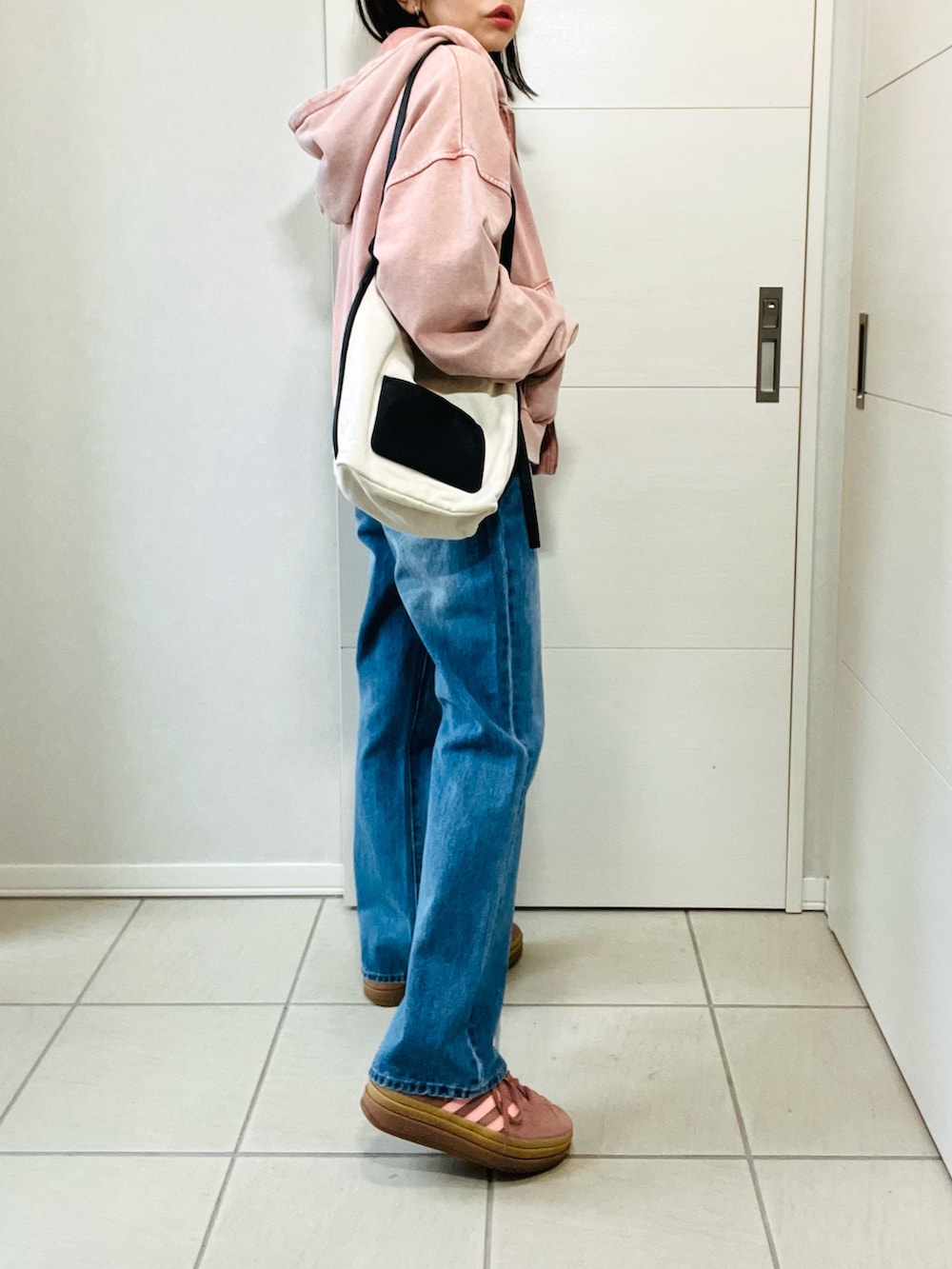 ブルー系のTシャツ/カットソー、ピンク系のパーカー、ブルー系のデニムパンツを着用したレディースの春コーディネートの5枚目の写真