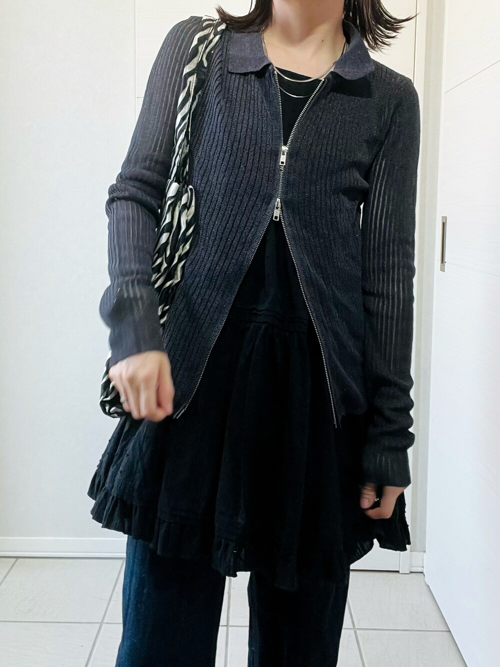 グレー系のカーディガン/ボレロ、ブラック系のワンピース、ブルー系のデニムパンツを着用したレディースの春コーディネートの2枚目の写真