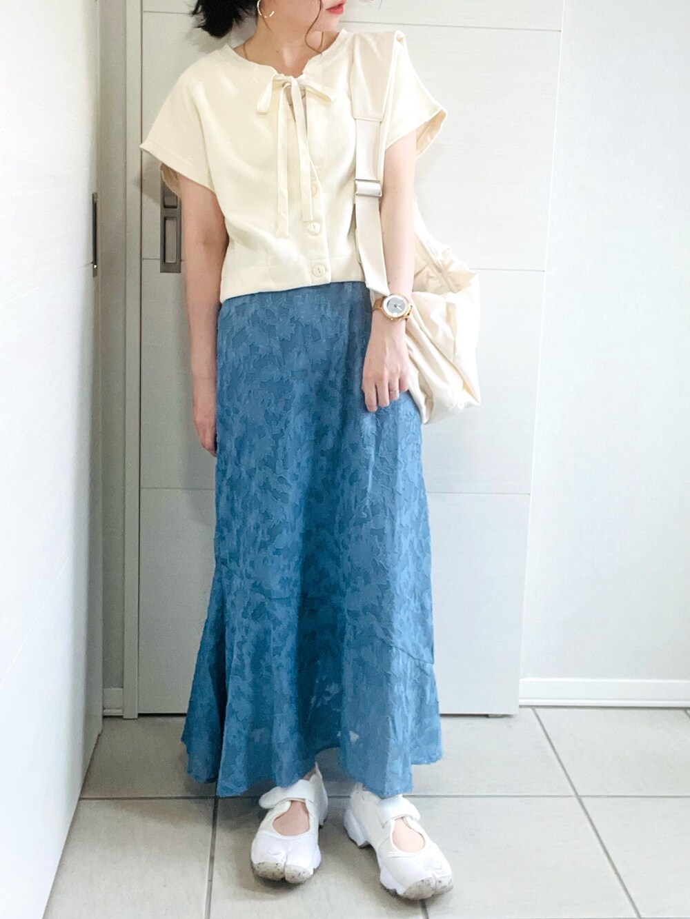 ホワイト系のカーディガン/ボレロ、ブルー系のスカート、ホワイト系のサンダルを着用したレディースの夏コーディネートの3枚目の写真