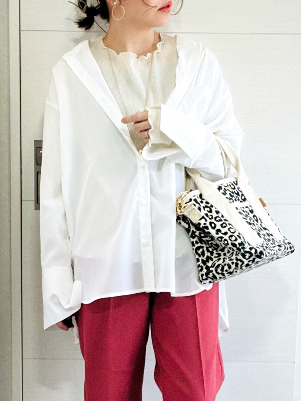 ホワイト系のシャツ/ブラウス、レッド系のスラックス、ホワイト系のスニーカーを着用したレディースの春コーディネートの3枚目の写真