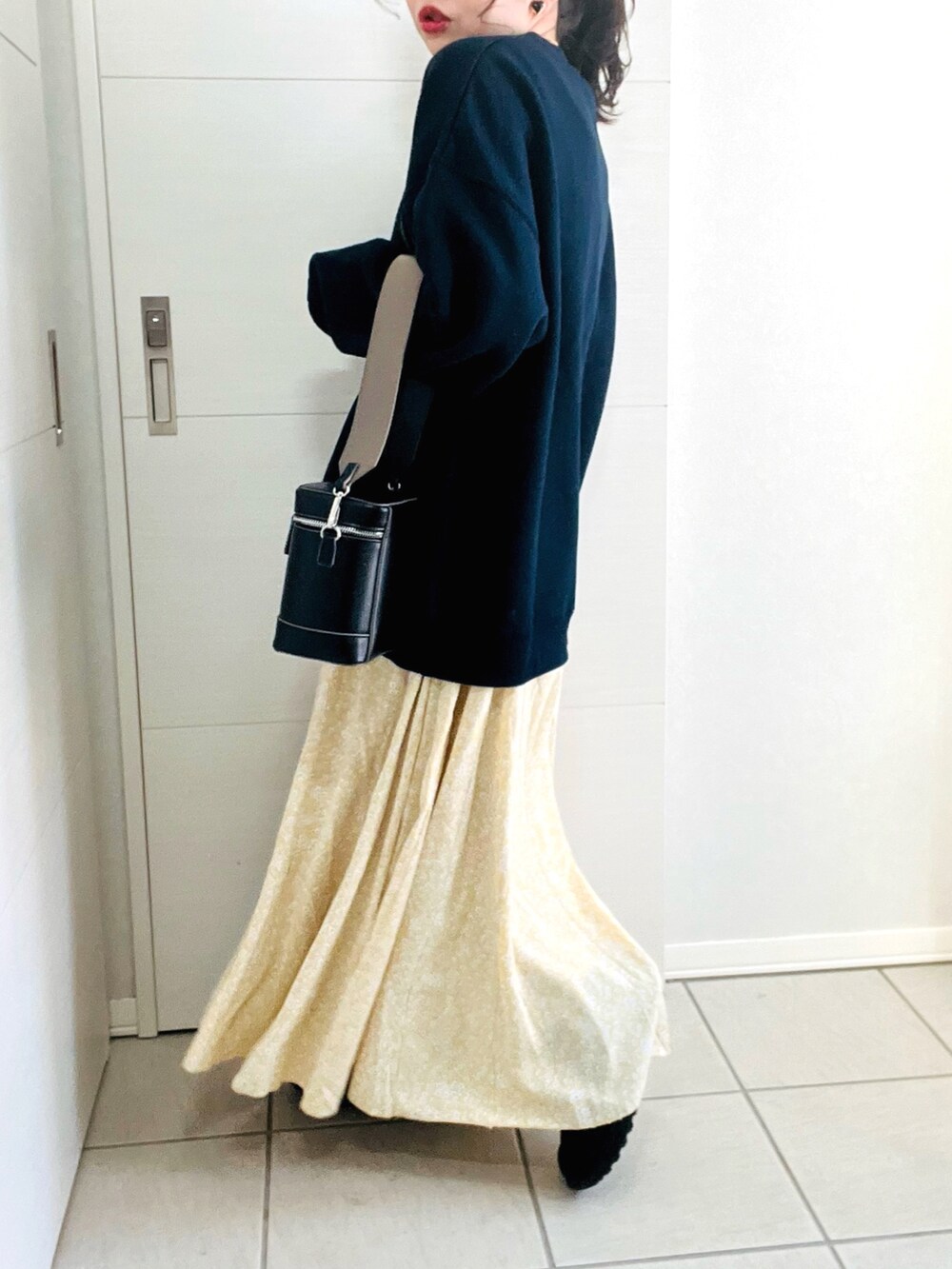 ブルー系のスウェット、イエロー系のスカート、ブラック系のスニーカーを着用したレディースの冬コーディネートの4枚目の写真