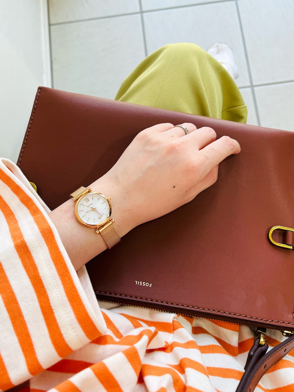 オレンジ系のTシャツ/カットソー、グリーン系のスラックス、ホワイト系のスニーカーを着用したレディースの春コーディネートの2枚目の写真