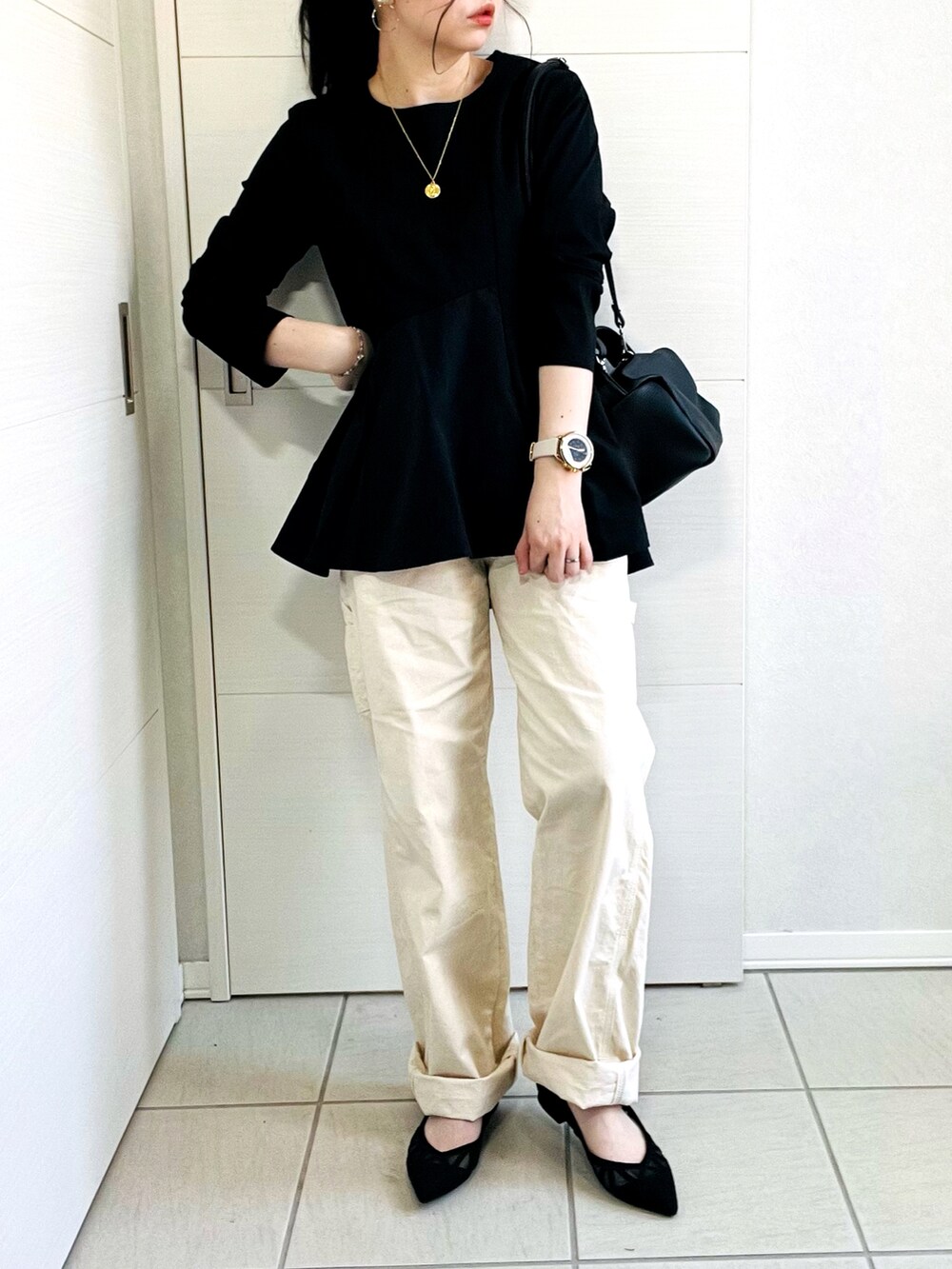 ブラック系のTシャツ/カットソー、ホワイト系のデニムパンツ、ブラック系のパンプスを着用したレディースの春コーディネートの5枚目の写真