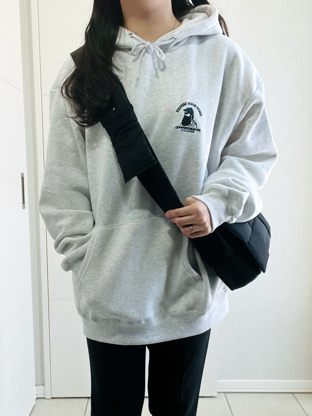 グレー系のパーカー、ブラック系のローファー、ブラック系のショルダーバッグを着用したレディースの春コーディネートの2枚目の写真